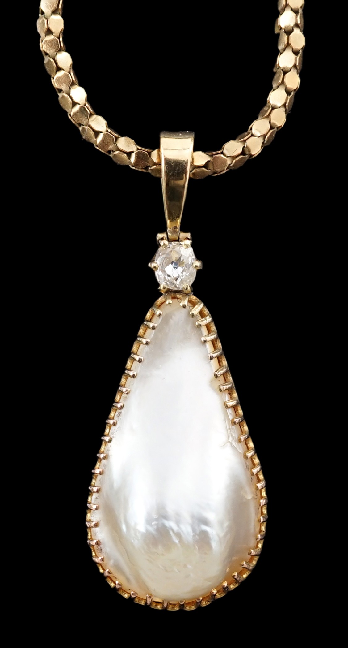 A 15ct gold mounted pear shaped baroque pearl and diamond set pendant, on an associated Italian 9k gold chain